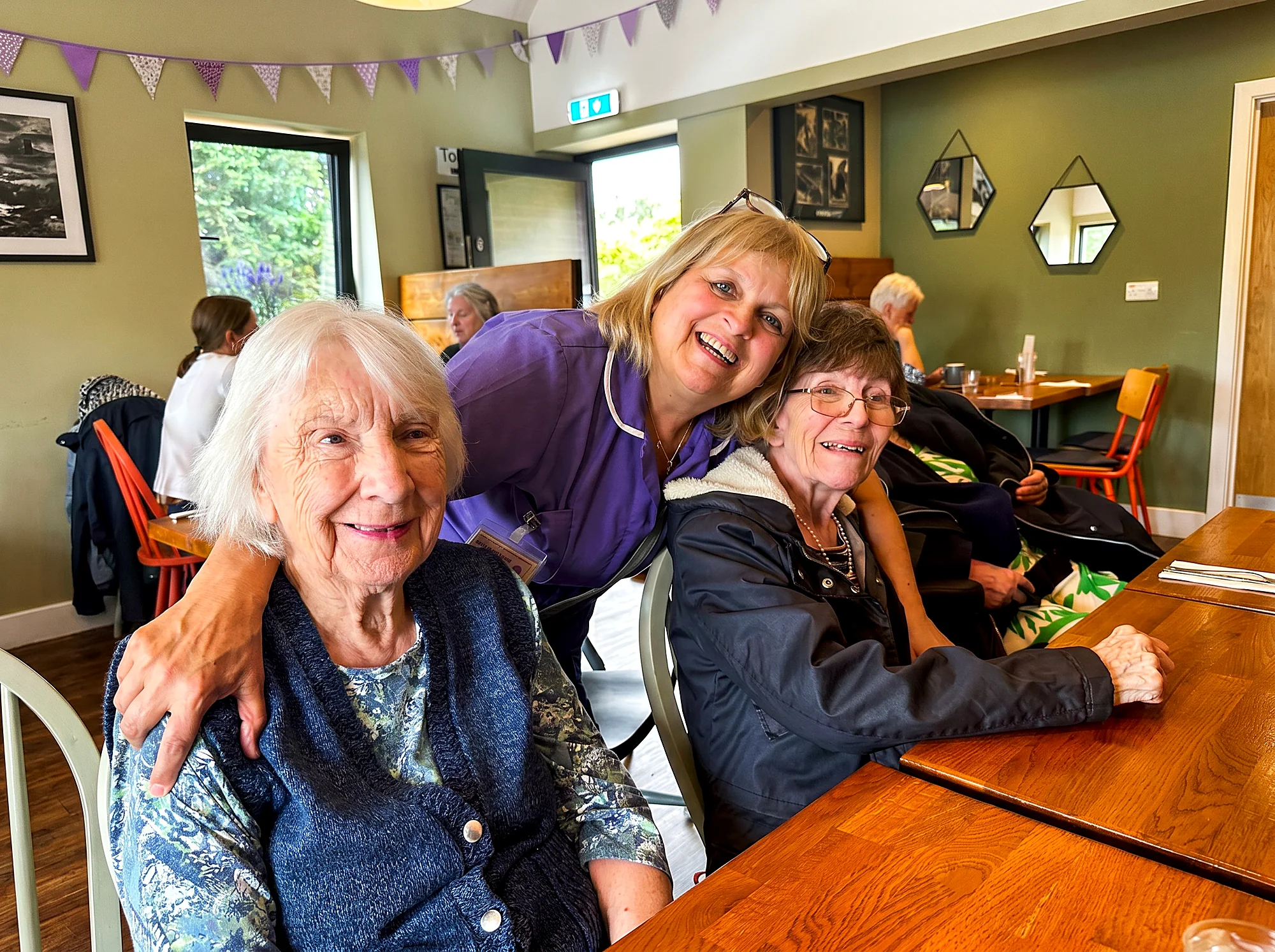 A carer sharing a happy moment with two residents at Castle House